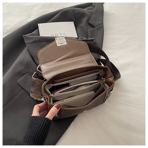 Detailed view of spacious inner compartments and secure zipper pockets in brown crossbody bag