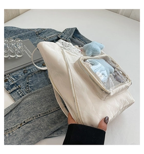 Détail du sac plissé blanc avec bordure en dentelle, fenêtre en PVC et breloque étoile