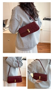 Detail of burgundy leopard print shoulder bag featuring a gold twist lock and matte finish