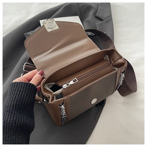 Detail view of the brown PU leather bag interior with multiple compartments and broad strap