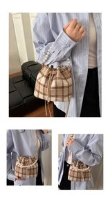 Detail of plaid bucket bag with pearl handle and leather drawstring closure