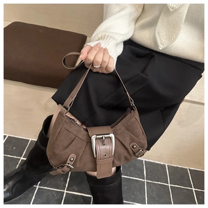 Detail der braunen Vintage-Eimertasche mit großer Silberschnalle und Akkordeon-Falten