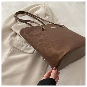 Detailansicht der braunen Totebag mit Leopardenprägung und goldenen Metallelementen