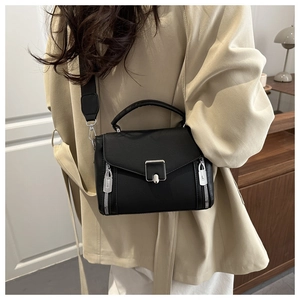Detail of black PU leather crossbody bag featuring silver metal clasp and decorative zippers