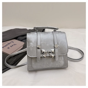Detailed view of a silver bow backpack with metallic finish and vertical strap design