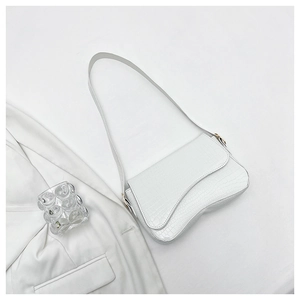 Close-up of white crocodile pattern shoulder bag with a sleek flap and curved base
