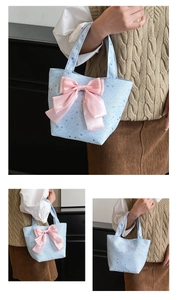 Detalle del bolso tote azul claro con estampado de estrellas y lazo de satén rosa grande