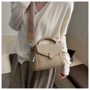 Detail of canvas leather crossbody bag with wide logo strap and metallic clasp