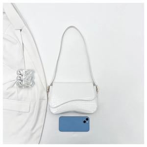 Detail of white crocodile pattern shoulder bag with a unique wavy cut flap and phone scale