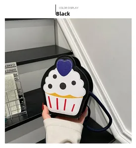 Detail of cute cupcake-shaped crossbody bag in black leather with heart patch