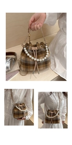 Detail of vintage plaid drawstring bucket bag with pearl handle and metal chain strap