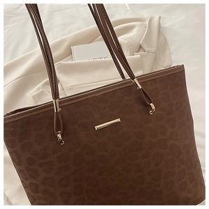 Detail der Totebag mit Leopardenmuster, goldener Schließe und brauner Wildleder-Textur