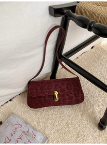 Close-up of retro leopard print handbag in burgundy with elegant gold metal buckle detail