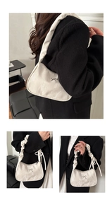 Details der weißen Lackledertasche mit Marmorstruktur, Silberbogen und Faltenriemen