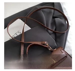 Detail of brown litchi pattern leather bag with golden twist lock and slim shoulder strap