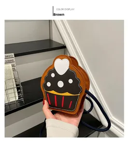 Detail of cupcake-shaped brown PU leather crossbody bag with blue rope strap and heart