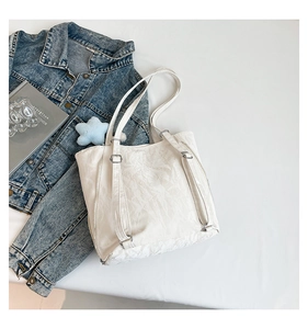 Détail de la texture du tissu plissé et de la boucle en métal du sac cabas blanc chic