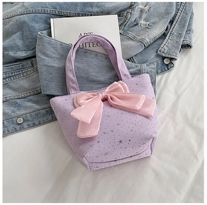 Detail of lilac tote bag with silver star prints and a large pink satin bow decoration