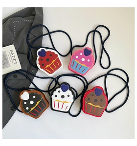 Flat lay of colorful cupcake shaped mini crossbody bags with heart patterns and strap