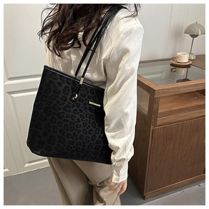 Detail der schwarzen Tote Bag mit Leopardenmuster, Goldbeschlägen und schmalen Trägern