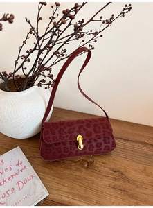 Detailed view of vintage leopard print burgundy shoulder bag with gold metal buckle