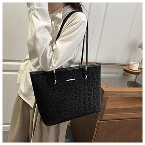 Detailansicht der Leoparden-Struktur auf schwarzer Wildleder-Tasche mit Golddetails