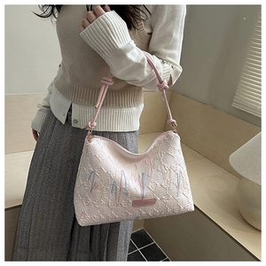 Detail of pink quilted canvas tote bag with abstract embroidery and knot shoulder strap