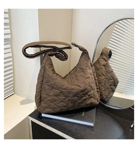 Detail of star-quilted pattern on dark brown nylon shoulder bag with luxury lighting