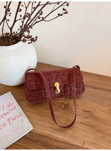 Close-up of vintage leopard print handbag in burgundy with elegant gold metal lock