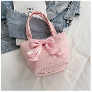 Pink fabric tote bag with silver star sequins and large bow detail on white surface