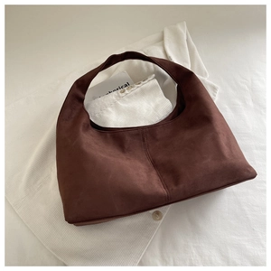 Close-up of vintage dark brown suede texture and stitching on the hobo tote bag
