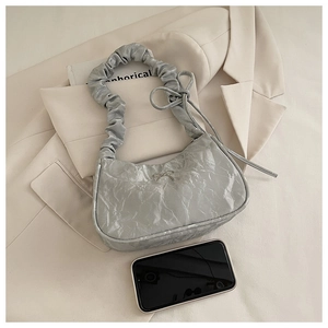 Silver pleated shoulder bag with metal bow detail and cloud-style ruffled strap