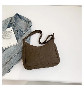Detailed view of dark brown quilted hobo bag with star patterns and adjustable strap