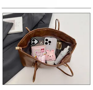 Close-up of brown vintage tote bag showing large capacity for phones and cosmetics