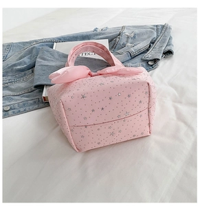 Detail of pink tote bag featuring silver star patterns and decorative bow handle