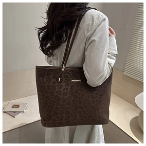 Detail der dunkelbraunen Totebag mit Leopardenmuster, Wildlederoptik und Metallplakette