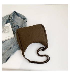 Detail of dark brown star-quilted hobo bag with adjustable nylon strap and zipper