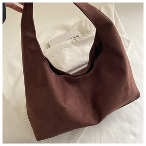 Macro shot of brown suede hobo bag texture with reinforced stitching and soft matte finish