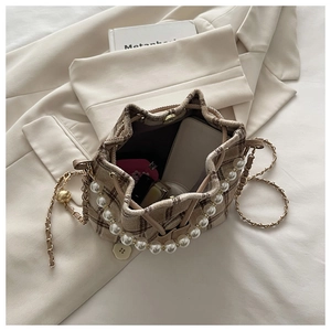 Detailed top view of plaid bucket bag interior with pearl handle and chain strap