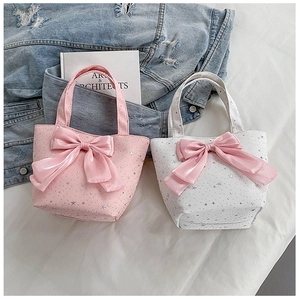 Detail showing two casual tote bags with pink bows and silver star prints on white fabric
