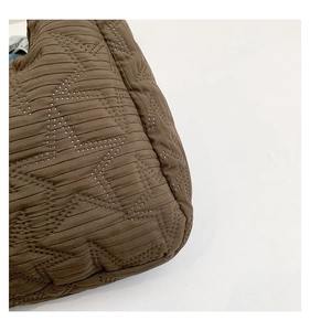 Detailed macro view of brown quilted fabric with star-shaped perforations and soft texture