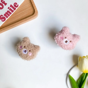 Dettaglio dei supporti per telefono a forma di orsetto di peluche su vassoio