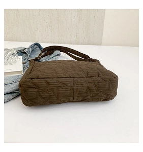 Detail of brown quilted bubble bag with star stitching and soft nylon texture