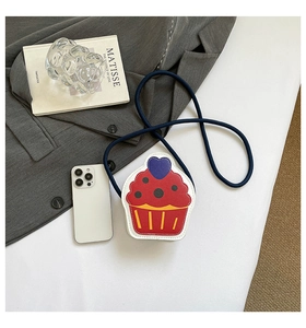 Détail d'un mini sac bandoulière en forme de cupcake avec rayures rouges et motif de cœur