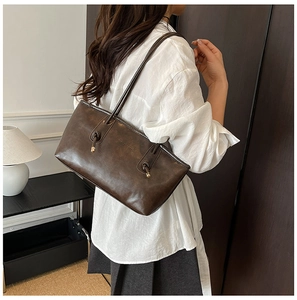 Détail du sac cabas en cuir marron foncé avec élégantes lanières à nœuds souples