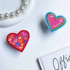 Macro shot of embroidered heart phone sockets with colorful patterns and letter detailing