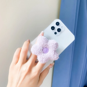 Detail of light purple plush flower griptok mounted on a white smartphone back