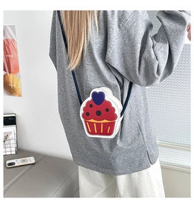 Detail of cupcake shaped PU leather crossbody bag with blue heart and strap decoration