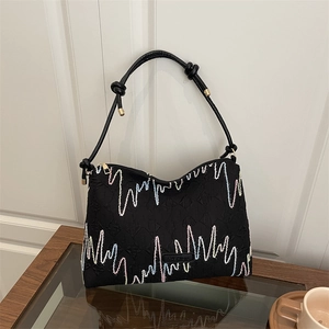 Black canvas tote bag with colorful wave embroidery and pleated texture details