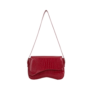 Red crocodile embossed commuter bag with wave base and asymmetric flap on white backdrop